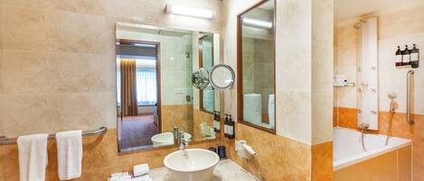 A modern bathroom with a large sink, mirror, and bathtub.