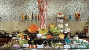 Un bufé con diferentes opciones de comida y un árbol decorativo.