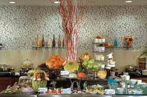 Un bufé con diferentes opciones de comida y un árbol decorativo.