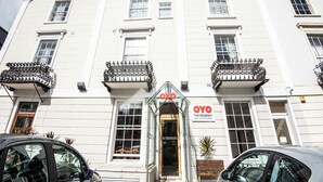 Un edificio blanco con balcones y un cartel que dice "OYO THE REGENCY HOTEL BAR-RESTAURANT".