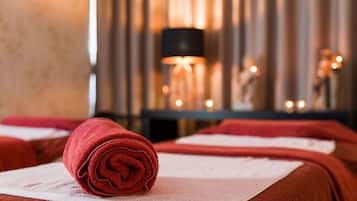 A neatly arranged massage area with towels and a lamp in the background.