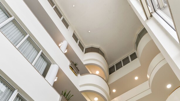 A multi-level atrium with balconies, recessed lighting, and potted plants. - Hotel Do Parque - Congress & SPA (Sao Pedro do Sul)