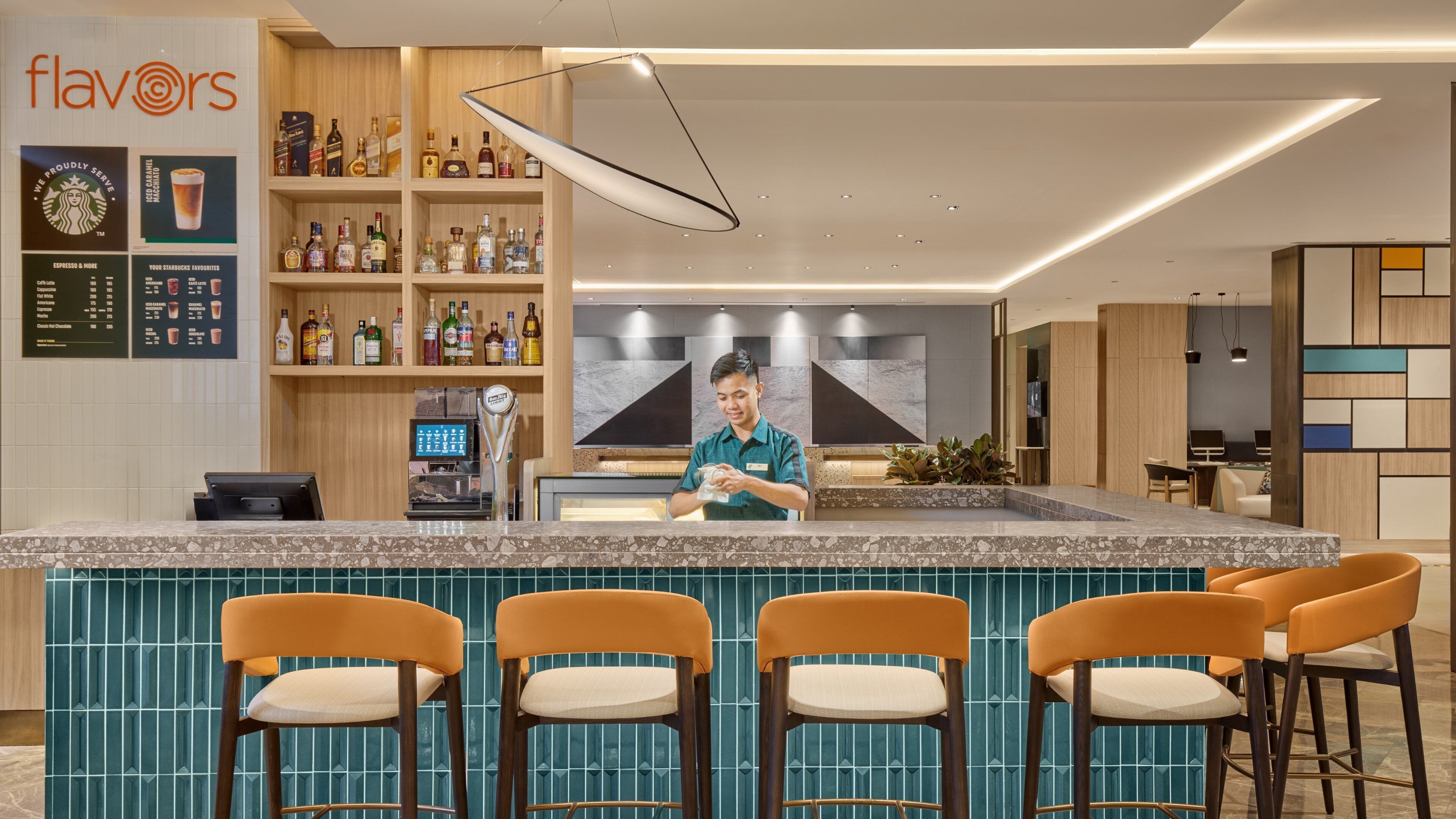 Eine moderne Bar mit einer Theke, Barhocker und einer Auswahl an Spirituosenflaschen.
