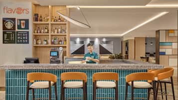 Eine moderne Bar mit einer Theke, Barhocker und einer Auswahl an Spirituosenflaschen.