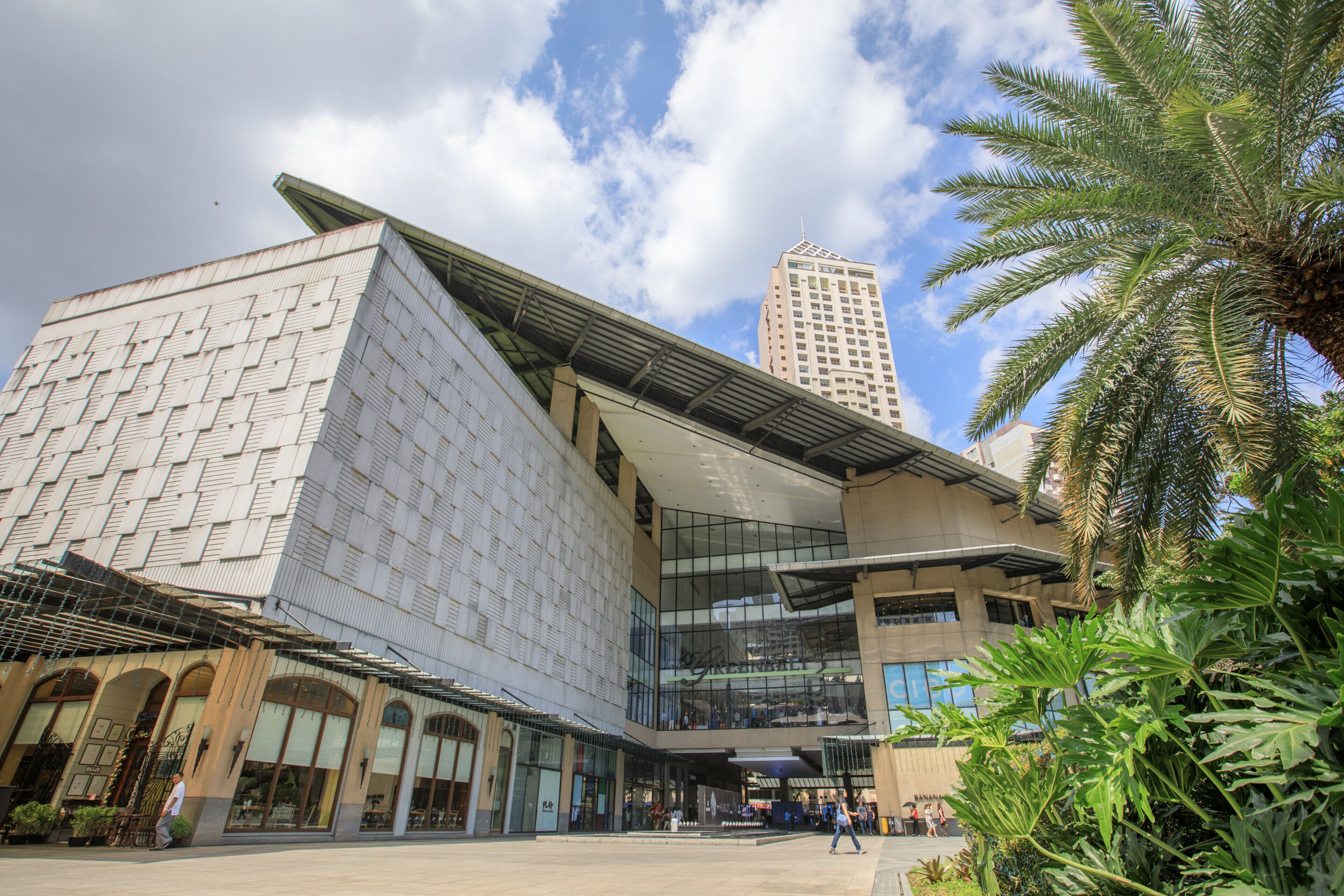 A modern building with a unique geometric facade, large glass windows, and a prominent entrance.