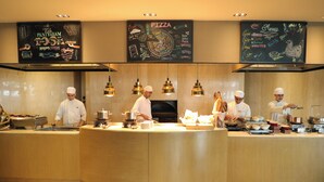A professional kitchen with chefs preparing food, a pizza menu, and a clean, modern design.