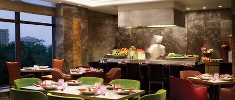 A restaurant with a high ceiling, modern decor, and a view of the cityscape.