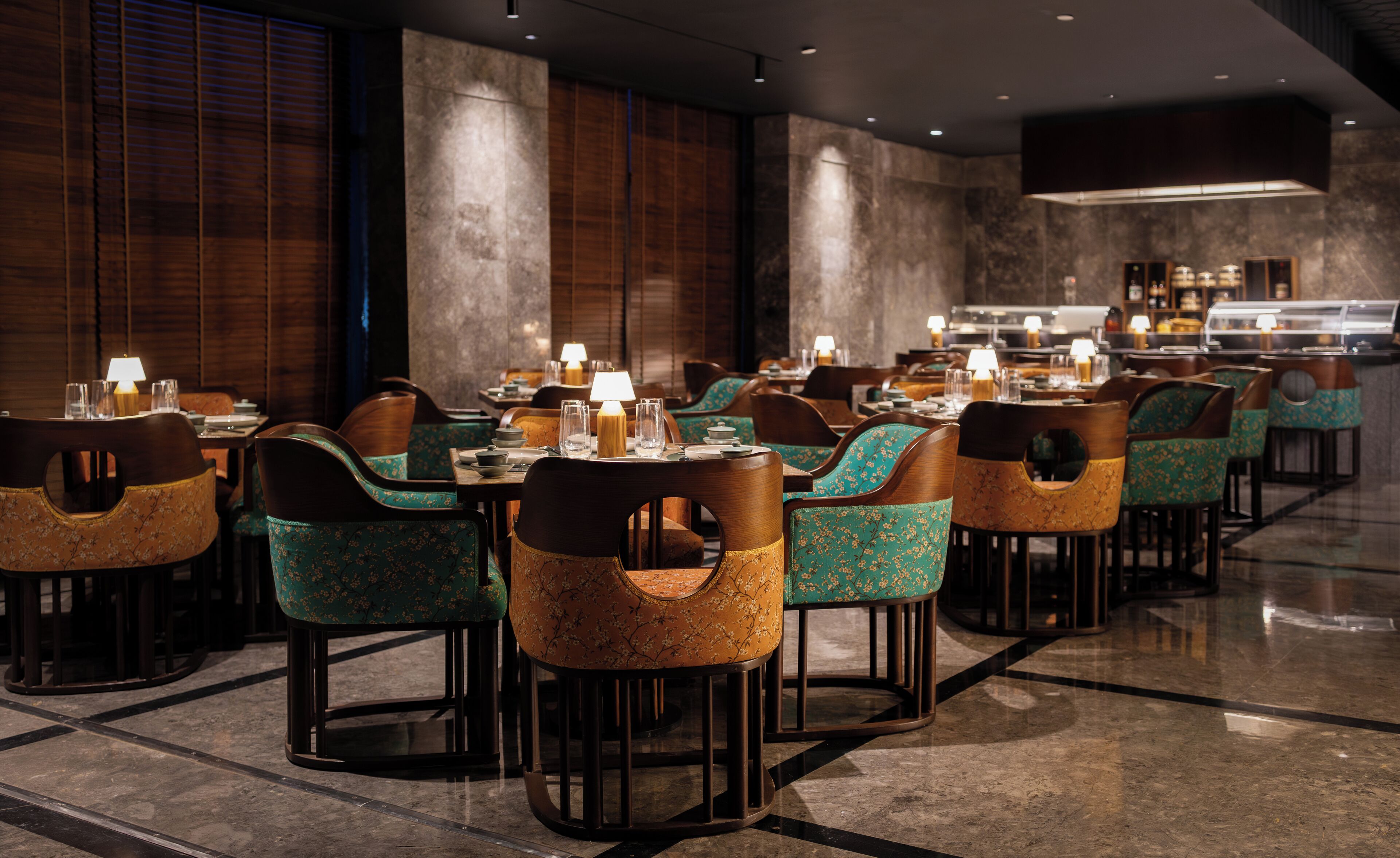 Un restaurante con varias mesas y sillas, cada una con una lámpara de mesa encendida.