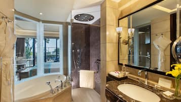 A modern bathroom with a large bathtub, a separate shower area, and a vanity with a large mirror.