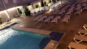 A poolside area with sun loungers and a pool. - Hotel Susuqui (Sanxenxo)