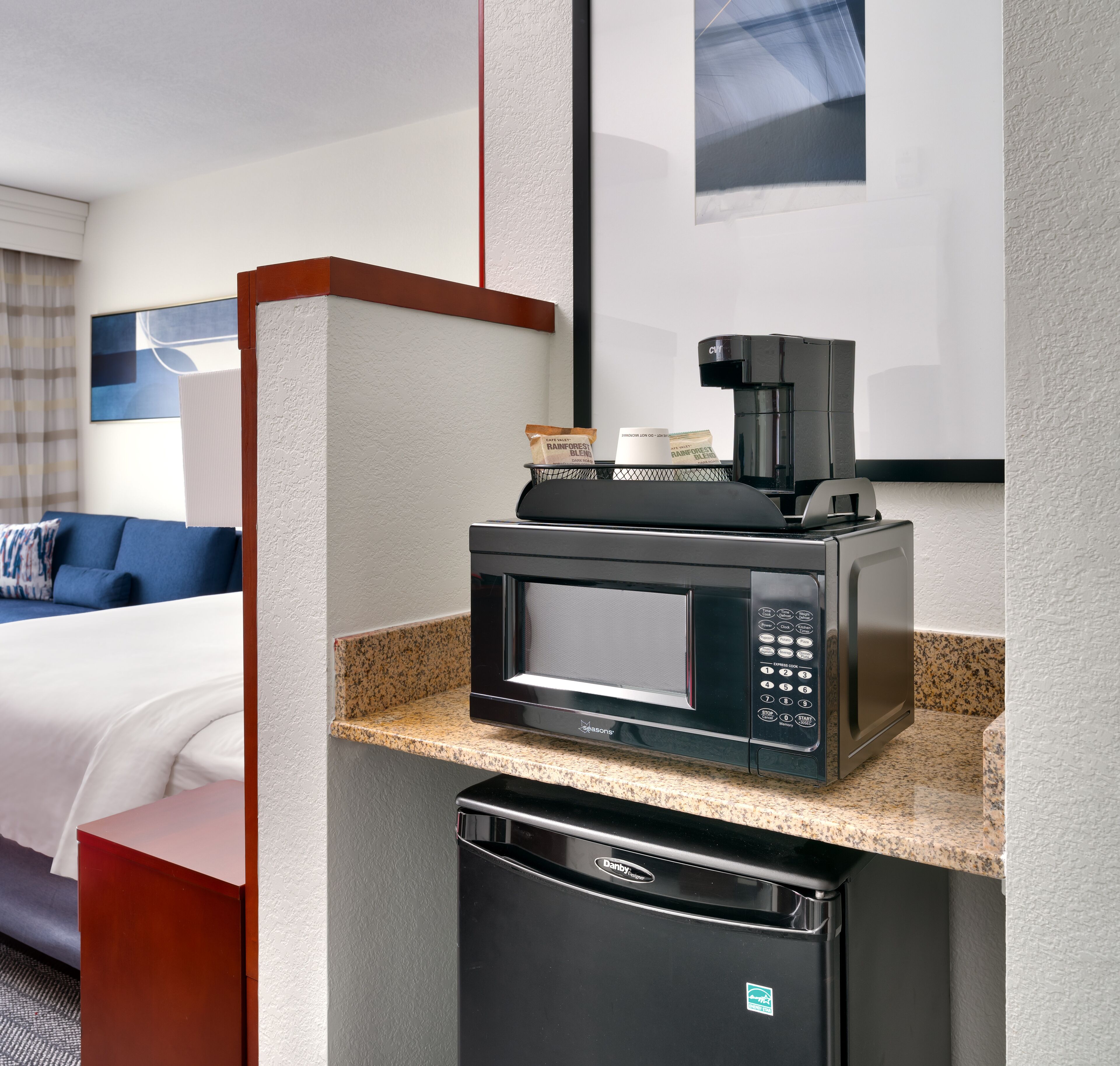 A compact kitchenette with a microwave, coffee maker, and a small refrigerator.