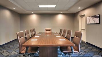 A conference room with a long table, multiple chairs, and a ceiling light.