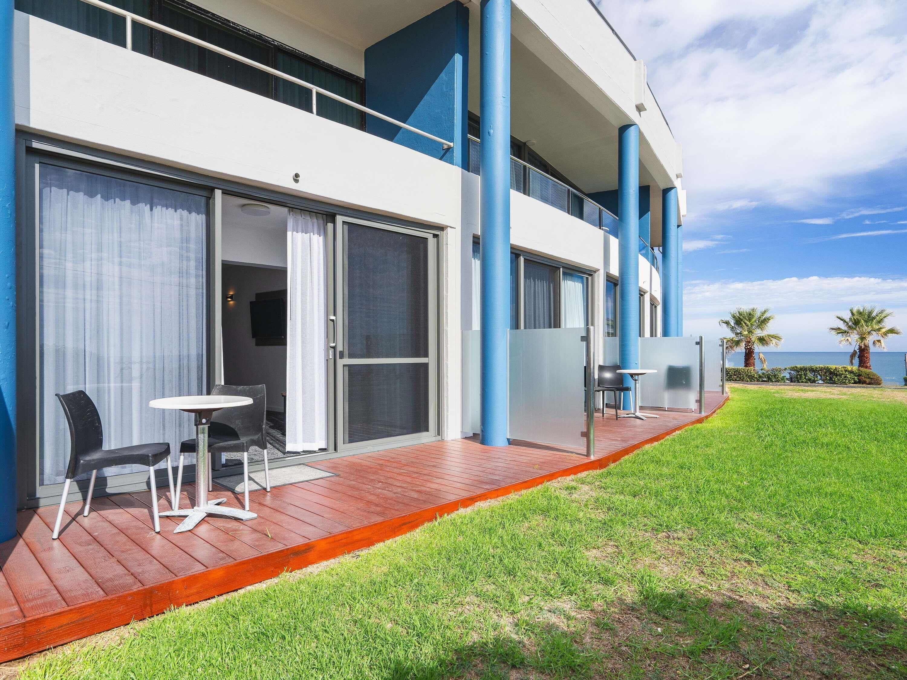 Un hôtel moderne doté d’un balcon, d’un espace extérieur aménagé et offrant une vue sur la mer.