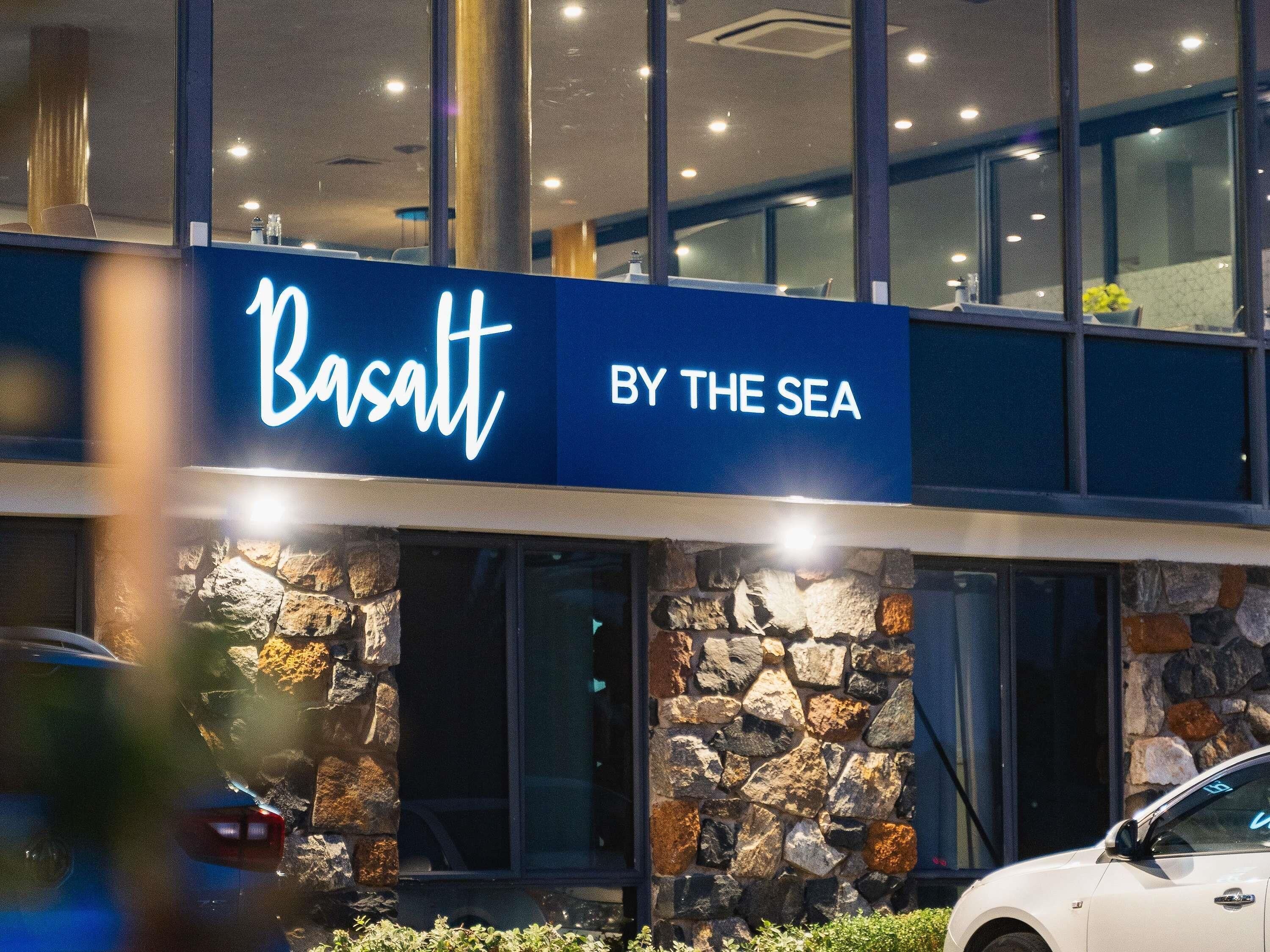 Un edificio con un cartello che riporta la scritta 'Basaul BY THE SEA'.