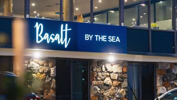 Un edificio con un cartello che riporta la scritta 'Basaul BY THE SEA'.