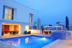 Una piscina al aire libre, sombrillas, sillones reclinables de piscina