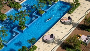 An aerial view of a swimming pool with geometric patterns, surrounded by lush greenery and shaded seating areas. - InterContinental Nha Trang by IHG (Nha Trang)