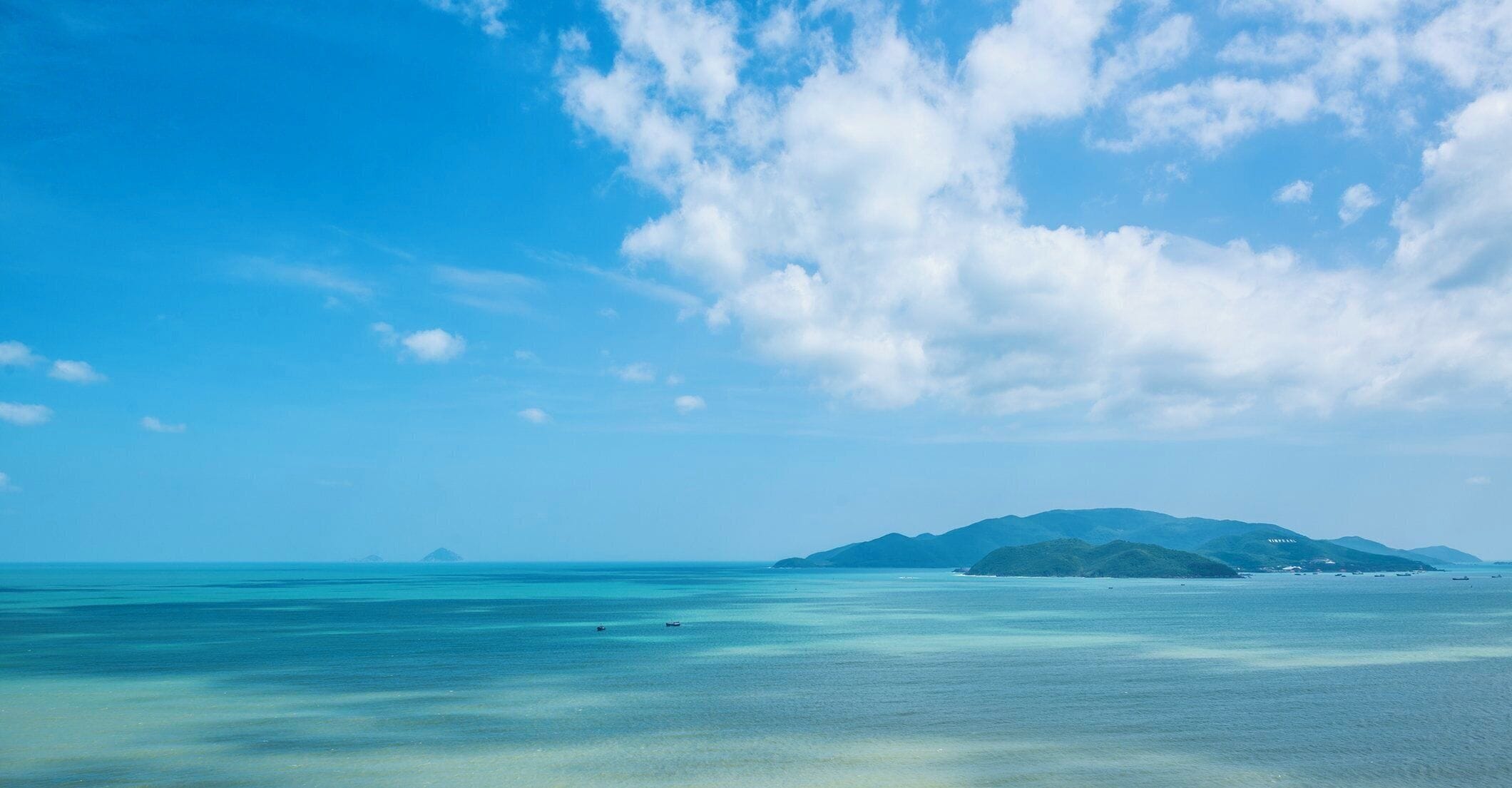 A coastal landscape with clear skies and calm waters.