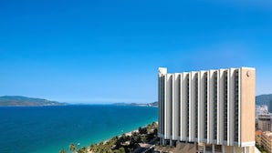A high-rise hotel with a view of the ocean and distant hills. - InterContinental Nha Trang by IHG (Nha Trang)