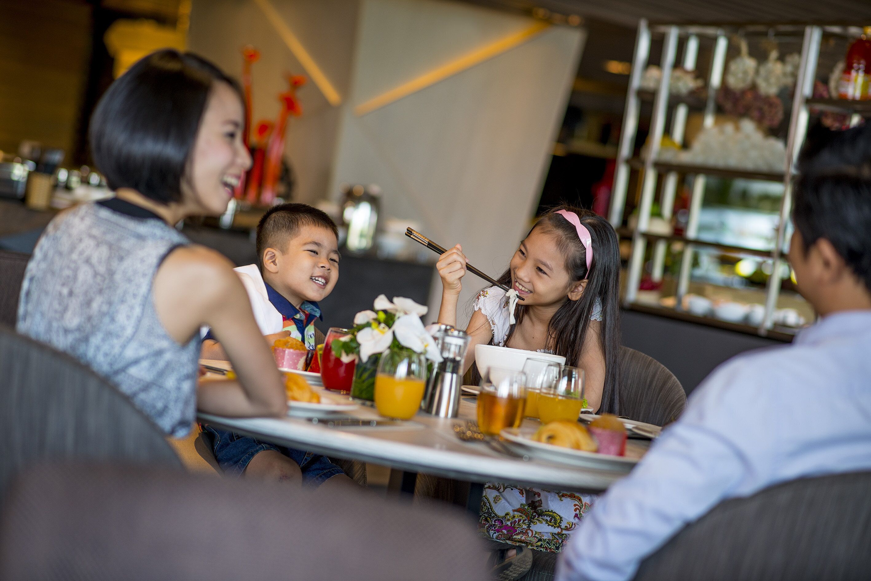 A dining area with tables, chairs, and a variety of food and drink items.