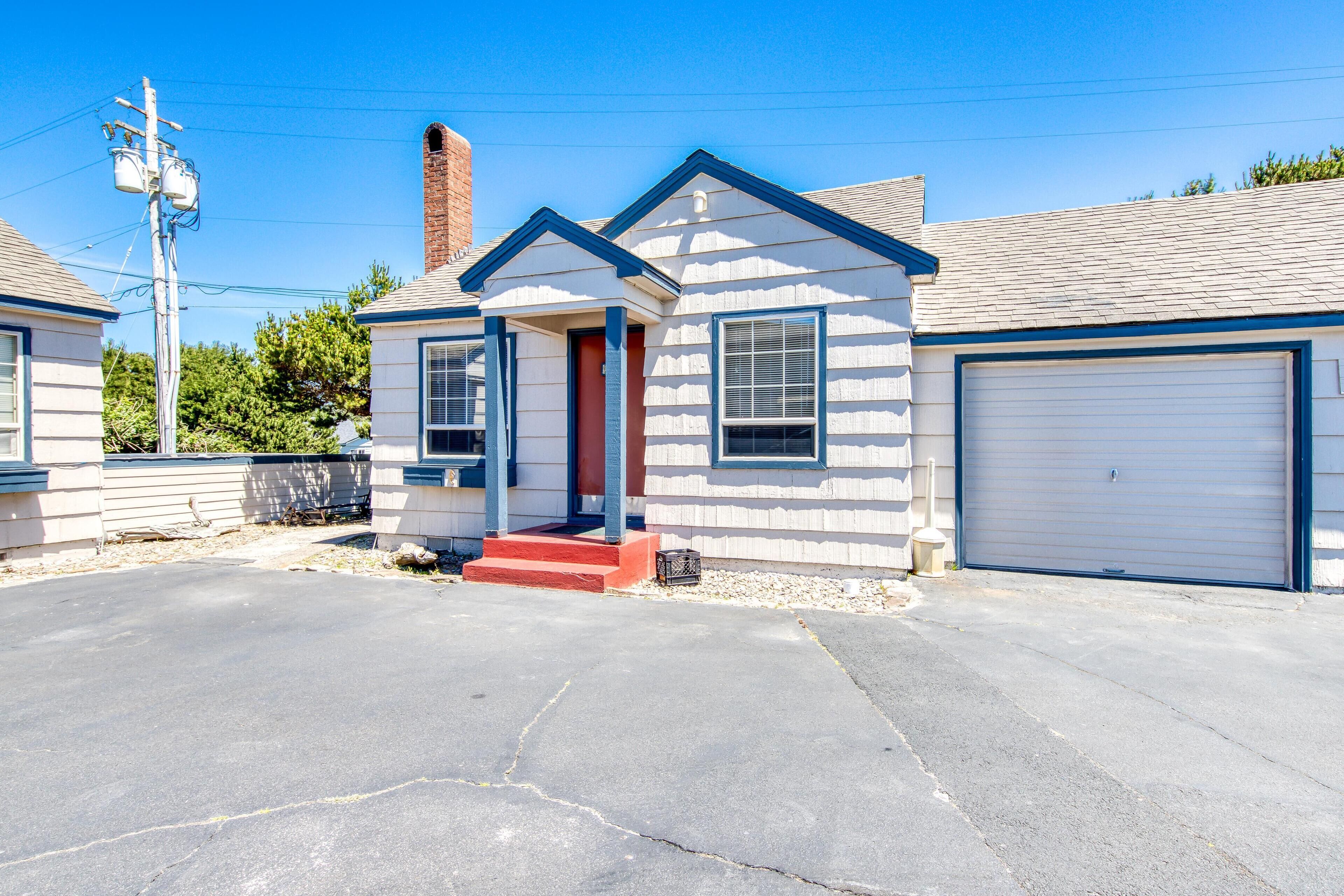 A single-story house with a garage, a chimney, and a driveway.