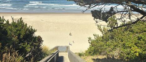 A concrete staircase leading to a beach with ocean views.