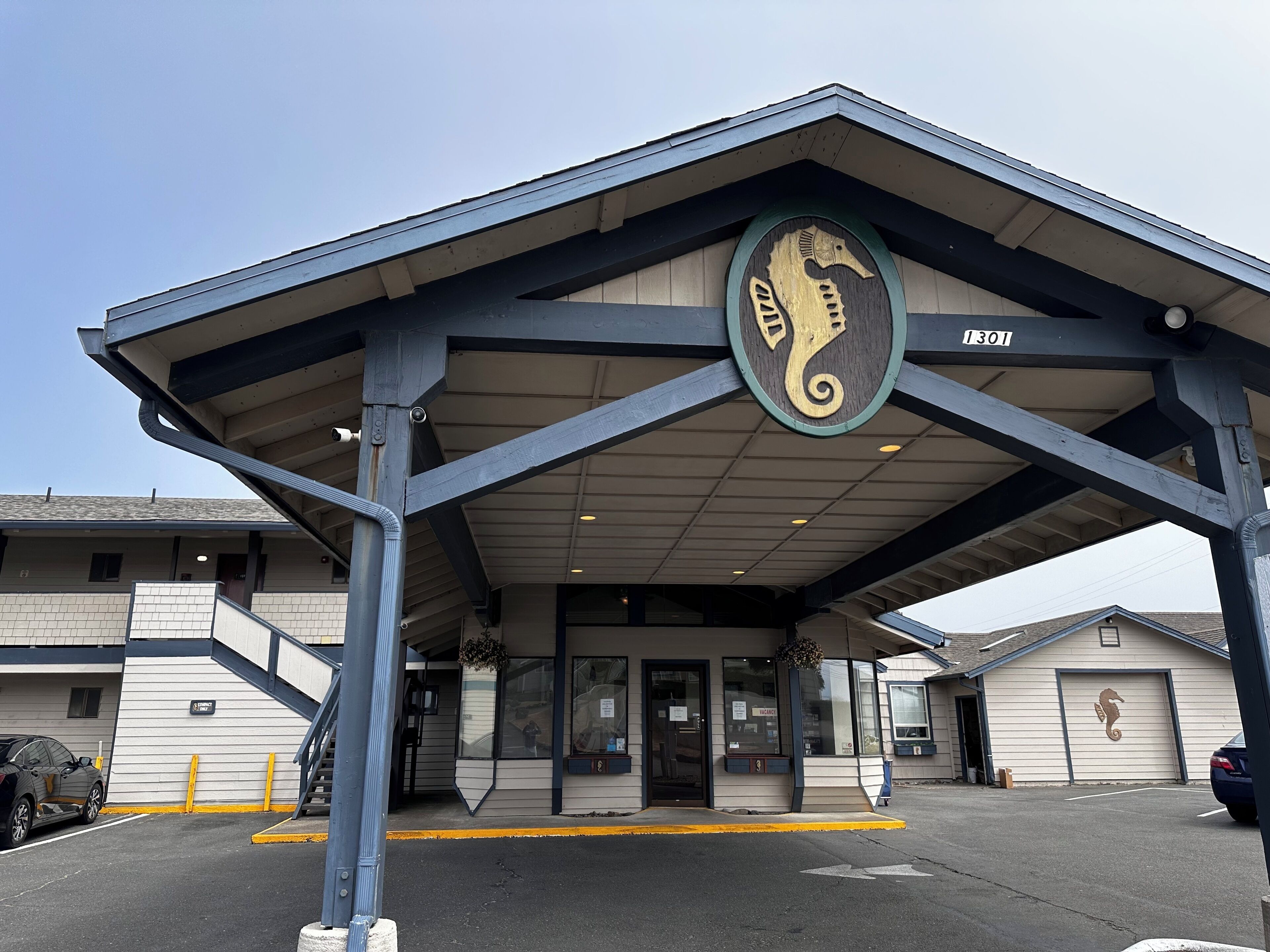 A building with a covered entrance, a seahorse logo, and the number 1301.