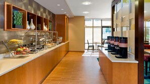 A hotel breakfast area with a long counter, various food items, and coffee machines. - SpringHill Suites by Marriott Philadelphia Langhorne (Langhorne)