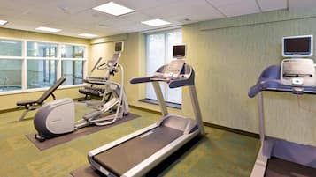 A fitness room with treadmills, elliptical machines, and a stationary bike.