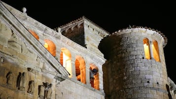A historic stone building with arched windows and a tower.