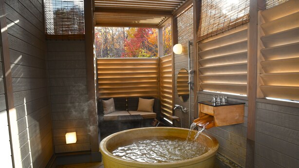 A sauna room with a large wooden tub, a bench, and a wall-mounted heater. - Karuizawa Club Hotel Karuizawa 1130 / Hewitt Resort (Tsumagoi)