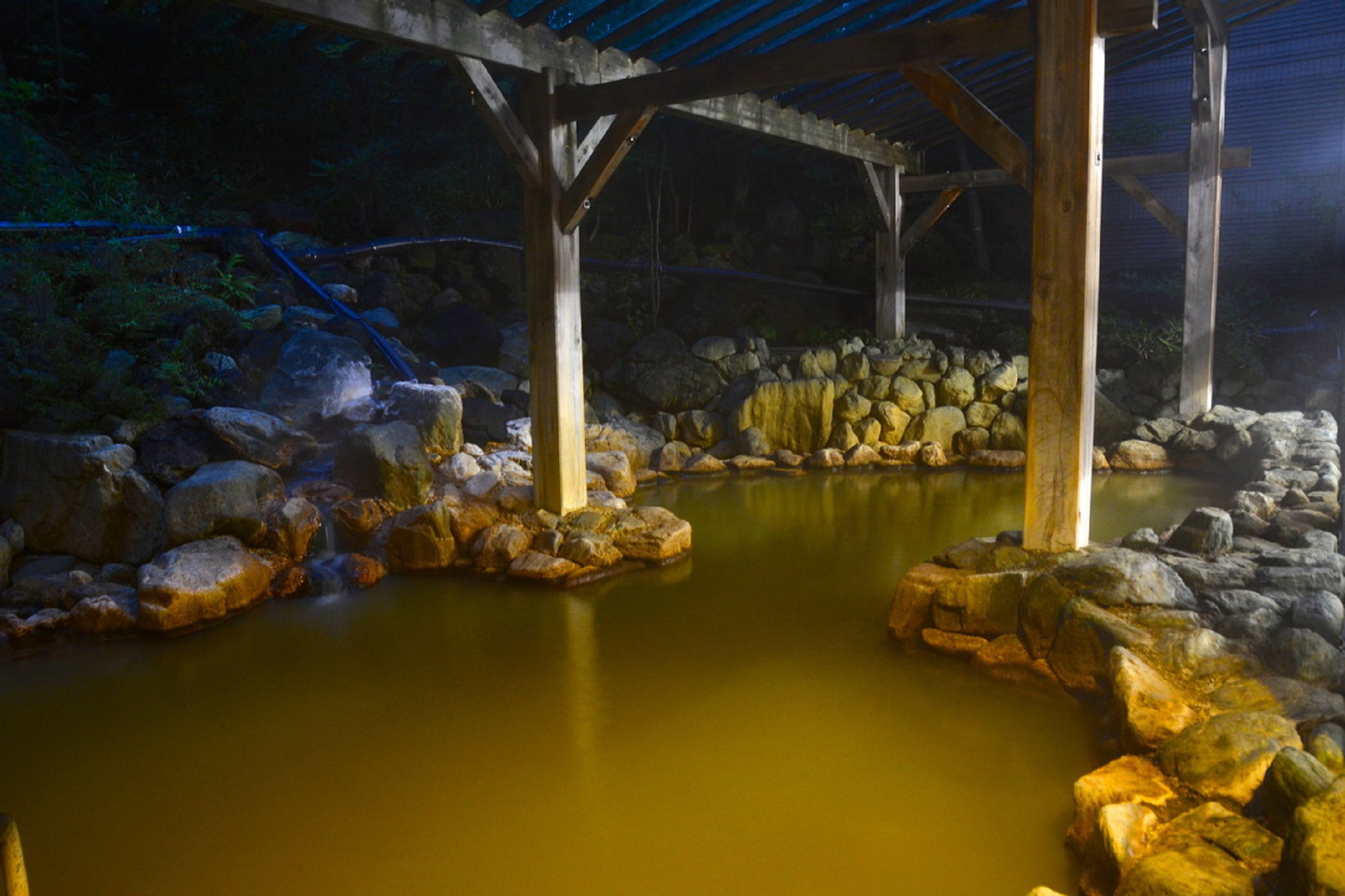 A stone bath area with a wooden structure overhead.