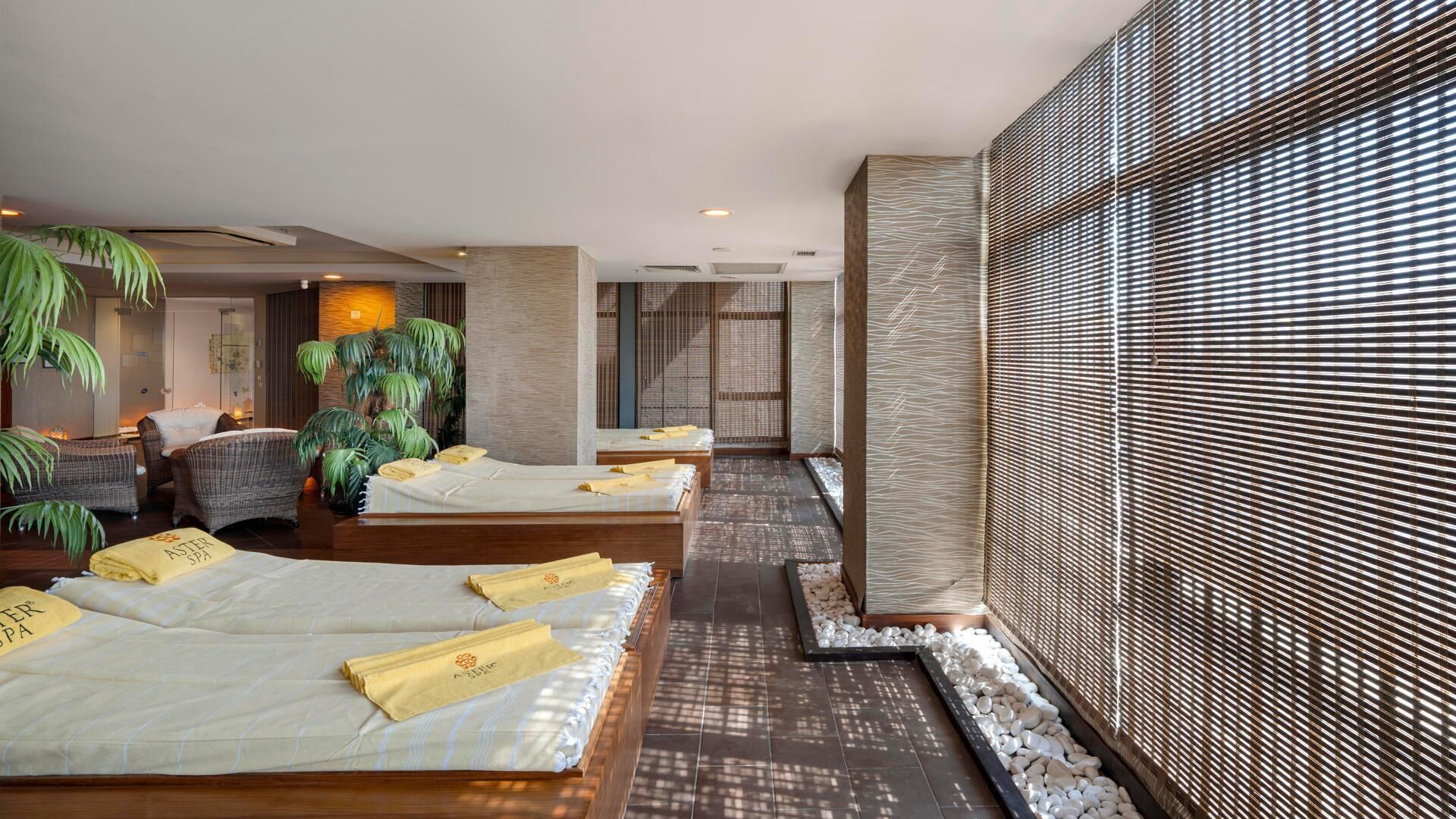 A spa room with three beds, a reception area, and a large window with a view.
