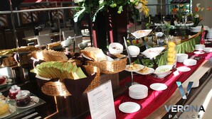 Een buffetopstelling met diverse gerechten en een bord waarop tekst staat.