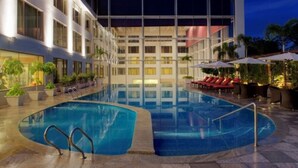 A modern hotel with a swimming pool, outdoor seating, and a well-lit facade. - Radisson Blu Plaza Hotel Hyderabad Banjara Hills (Hyderabad)