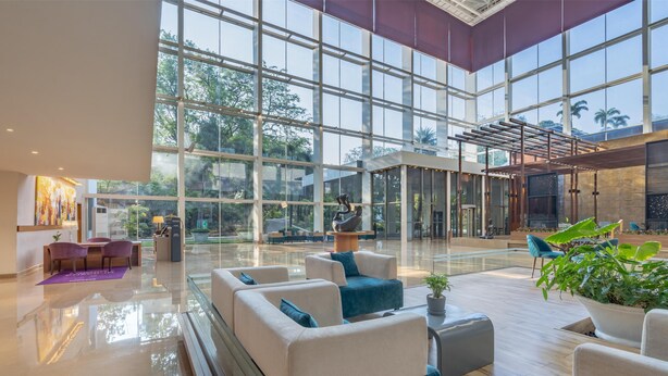 A spacious lobby with large windows, seating areas, and a reception desk. - Radisson Blu Plaza Hotel Hyderabad Banjara Hills (Hyderabad)
