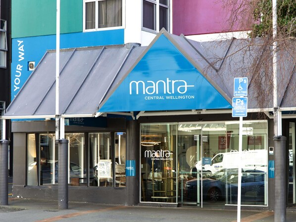 A building with a blue awning and the name 'mantra Central Wellington' on the facade.