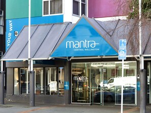 Un edificio con toldo azul y el nombre 'mantra Central Wellington' en la fachada.