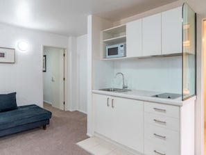 Apartment, 1 Bedroom, Kitchen | Desk, laptop workspace, iron/ironing board, travel cot