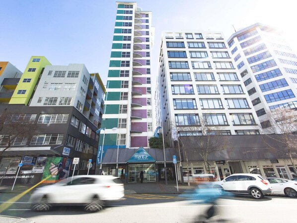 Un edificio de varios pisos con espacios residenciales y comerciales, incluyendo una fachada visible con rótulos.