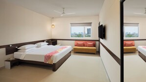 A hotel room with a large bed, a sofa, a TV, and a city view. - Ginger Mumbai Andheri (MIDC) (Mumbai)