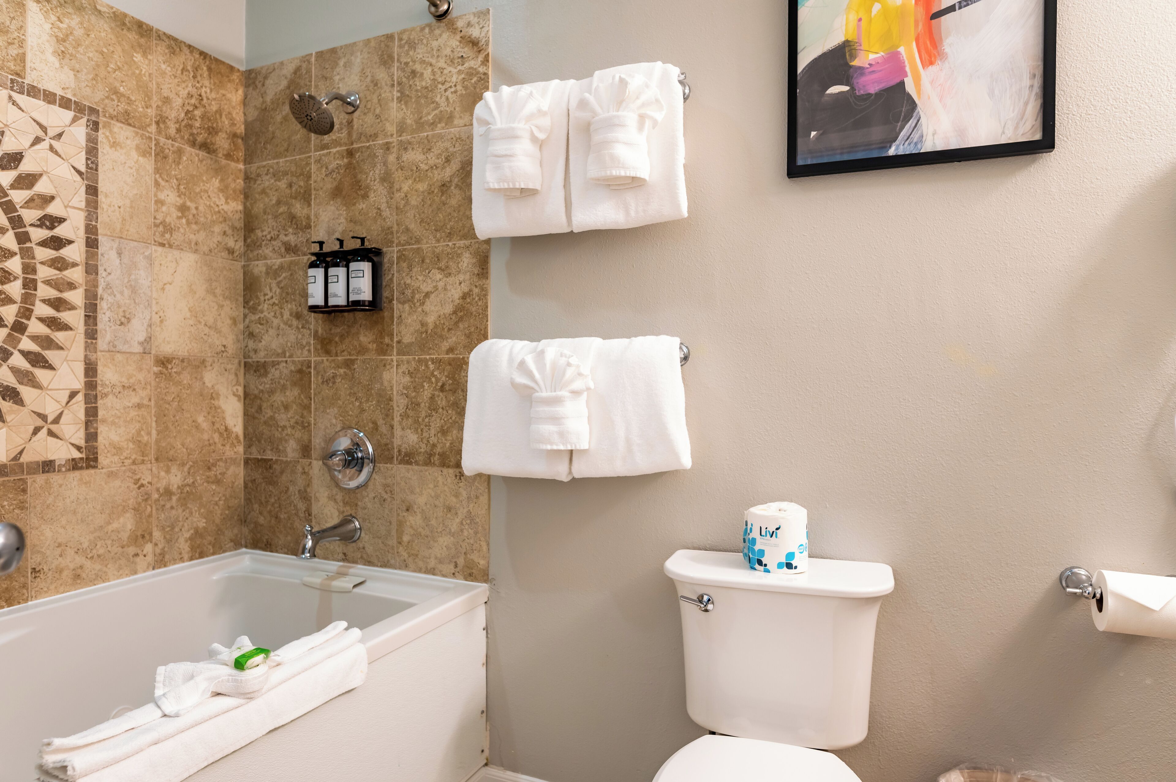A bathroom with a bathtub, toilet, and towels.