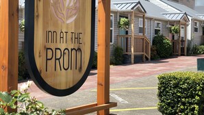 A wooden sign with a leaf design and the text "Inn at the Prom" indicating a lodging establishment. - Inn at the Prom Oceanfront Seaside (Seaside)