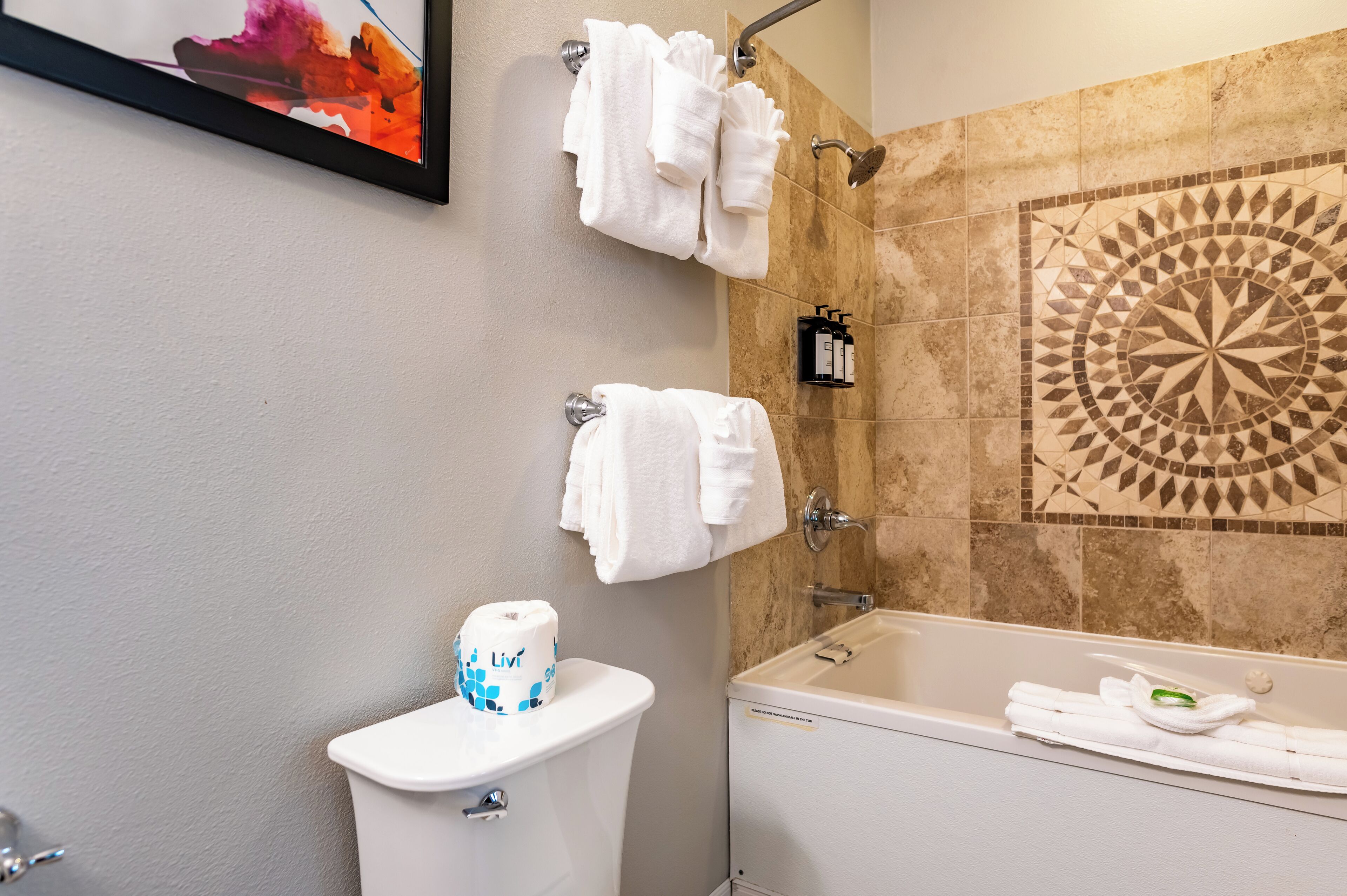 Ein Badezimmer mit Toilette, Badewanne und Handtüchern an einem Wäscheständer.