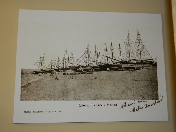 Fotografía en blanco y negro de un puerto deportivo con varios veleros amarrados.