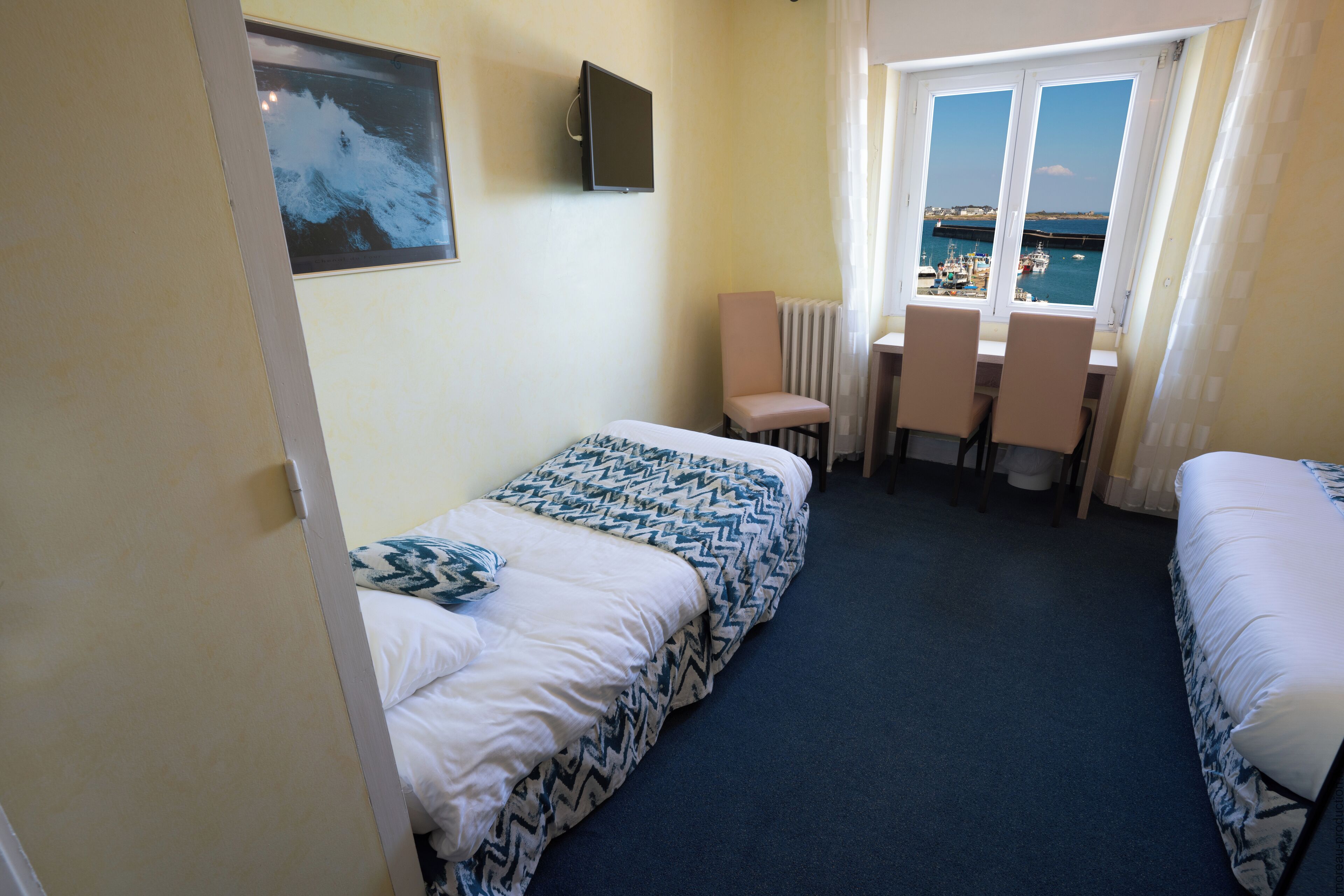 Hotellihuoneessa on kaksi sänkyä, työpöytä ja tuoli. Huoneesta on ikkuna, josta avautuu näkymä merelle ja veneisiin.