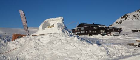 A snow-covered landscape with a building and a sled.