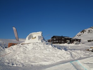 Un paisaje nevado con un edificio y un trineo.