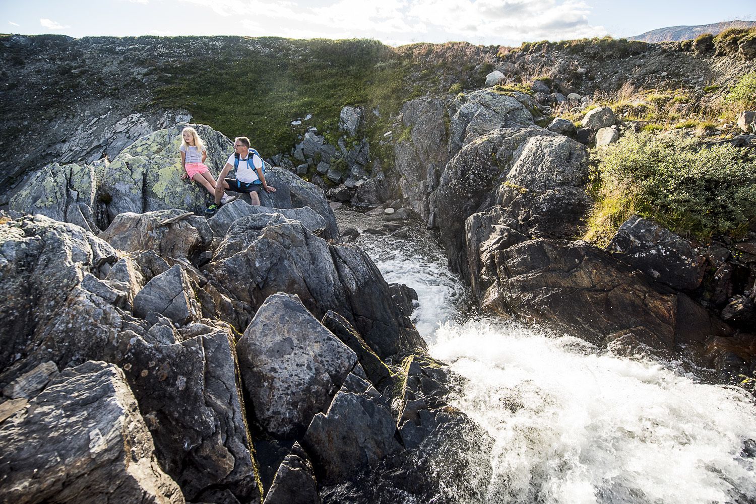 A rocky landscape with a river flowing through it.