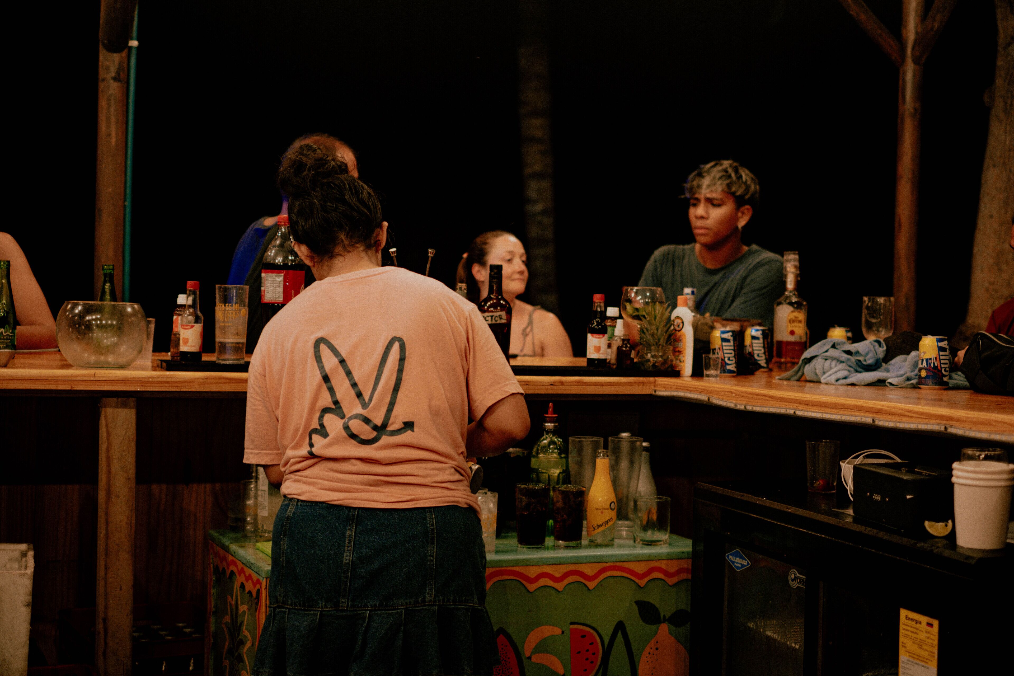 Un espace bar avec des comptoirs en bois et une variété de bouteilles et de verres.